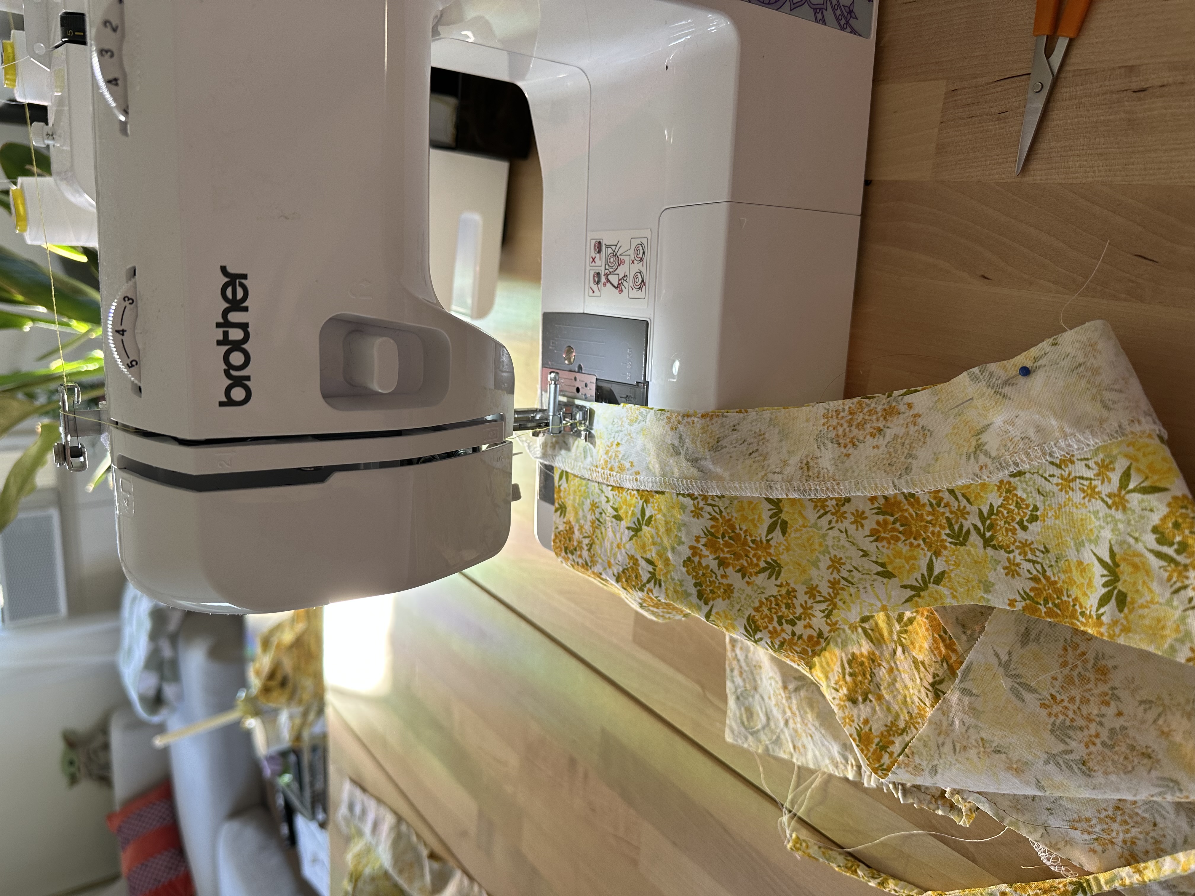 Emily's Brother XM2701 sewing machine stitching a yellow floral fabric